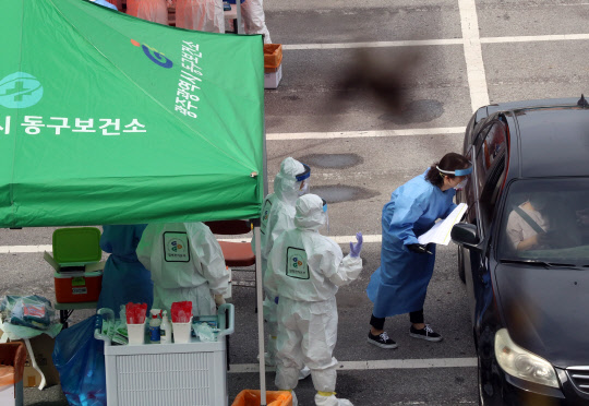 어린이집 확산 '비상'   어린이집 원생 남매 2명이 코로나19 확진 판정을 받은 가운데 6일 오전 광주 동구청 주차장에 마련된 임시 드라이브스루 선별진료소에서 동구보건소 직원들이 확진자가 나온 어린이집 원생들과 가족들을 대상으로 검체를 채취하고 있다. 연합